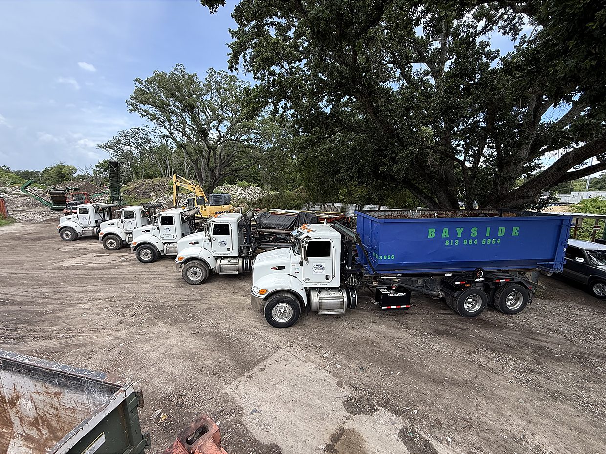 Global Recycling roll-off trucks and dumpster at the Tampa yard