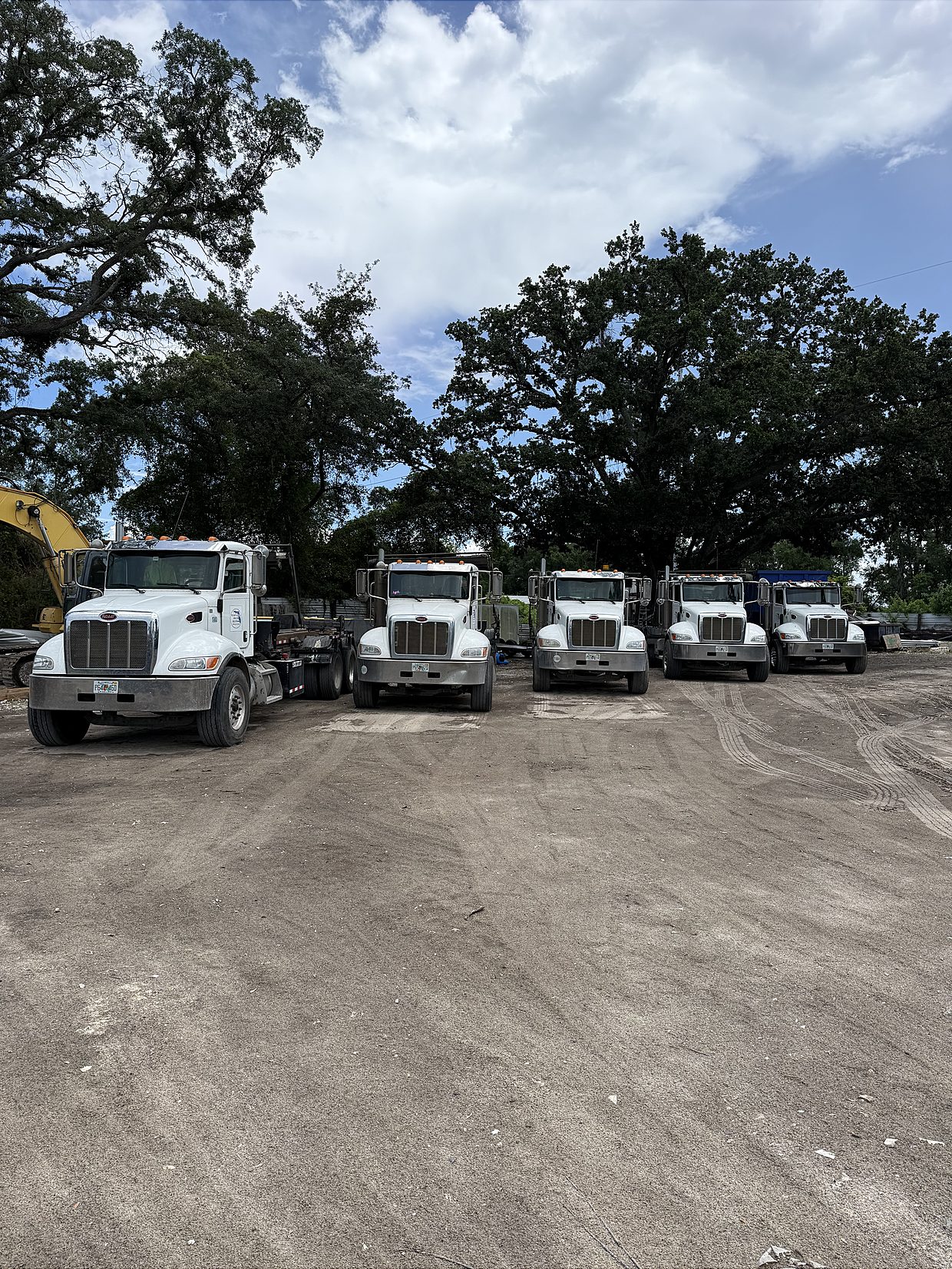 Fleet of Global Recycling roll-off trucks lined up